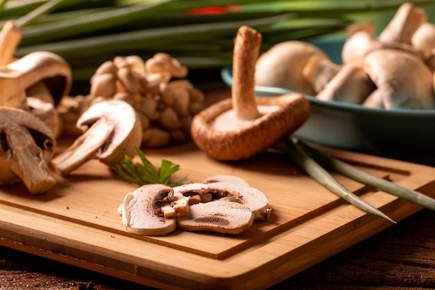 Vários tipos de cogumelos em uma mesa de madeira.