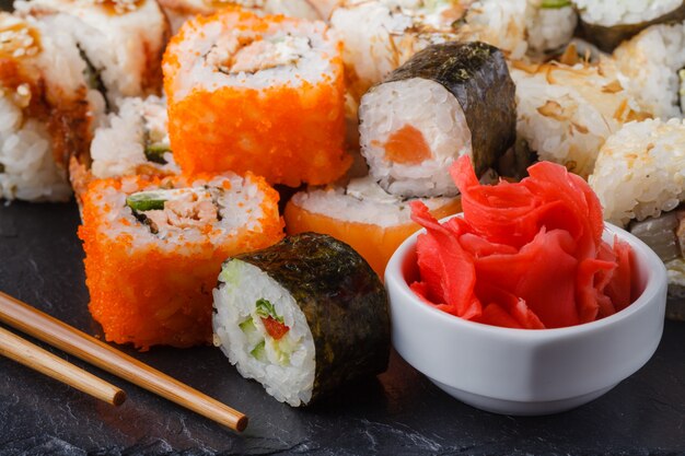 Vários tipos de comida de sushi servidos em pedra preta