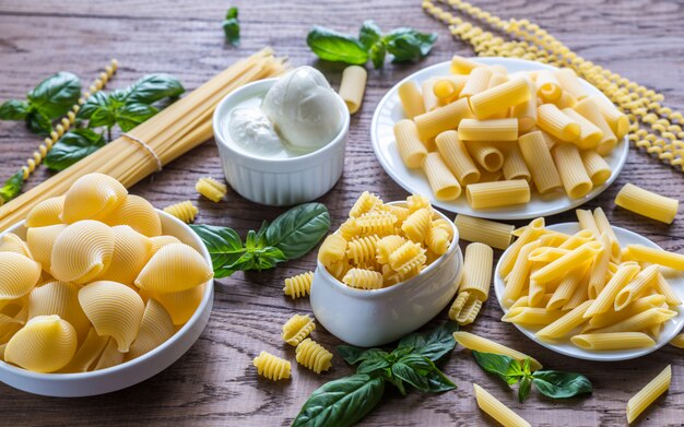 Vários tipos de macarrão no fundo de madeira