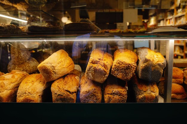 Vários tipos de pão recém-cozido exibidos nas prateleiras de uma padaria artesanal local