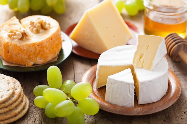 Foto vários tipos de queijo com mel de uvas e nozes