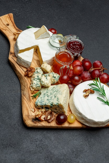 Vários tipos de queijo e geléia na tábua de madeira