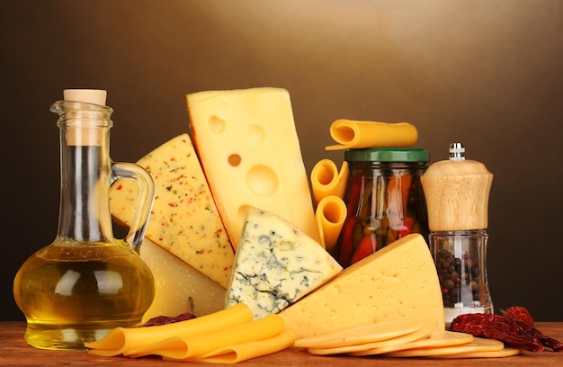 Vários tipos de queijo na mesa de madeira no fundo marrom