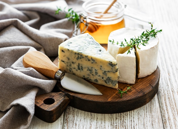 Vários tipos de queijo, queijo azul, bri, camembert e mel