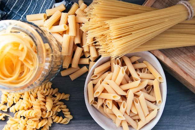 Varios tipos de pasta cruda en la cocina.