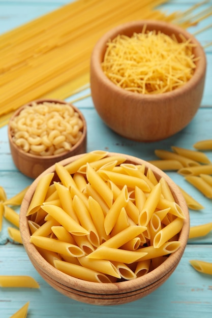 Varios tipos de pasta italiana sobre fondo azul.