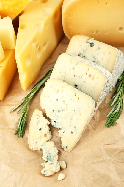 Varios tipos de queso con romero en la mesa de cerca