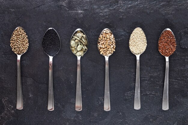 Varios tipos de semillas en cucharas