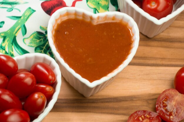 Varios tomates pequeños dentro de tres cuencos sobre una mesa de madera