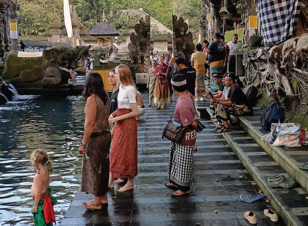 Varios turistas extranjeros se purifican en el templo de Tirta Empul en Bali