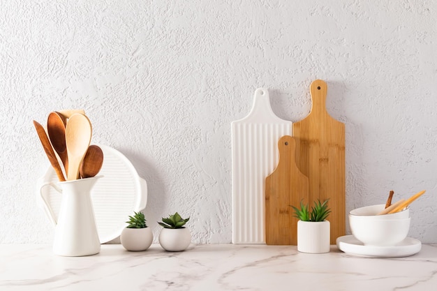 Vários utensílios de cozinha em uma bancada de mármore branco em uma cozinha moderna o conceito de decoração no contexto de uma parede cinza texturizada