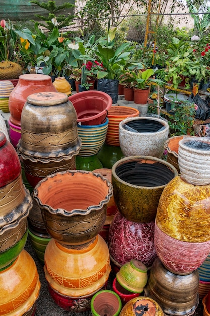 Vários vasos de cerâmica de diferentes tamanhos e cores dentro de um viveiro de plantas