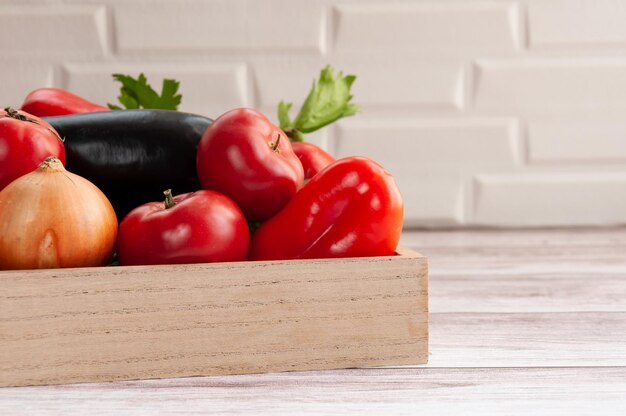 Vários vegetais em uma caixa Alimentos Tomates cebolas pimentas pepinos