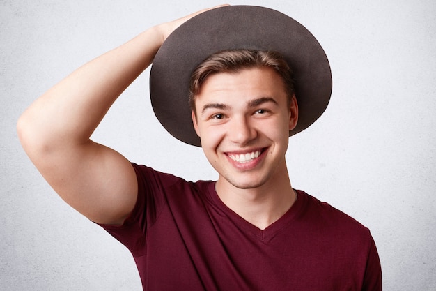 Varón joven alegre positivo con amplia sonrisa