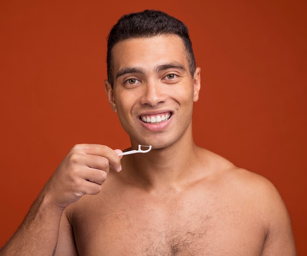 Foto varón joven con hilo dental