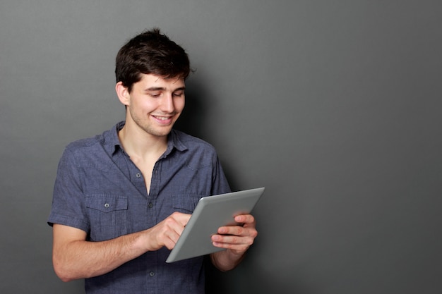 Foto varón joven sonriendo con tableta digital