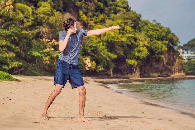 Varón joven trabajando en la playa, hombre deportivo haciendo ejercicios