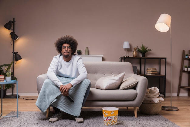 Varón joven viendo televisión en casa