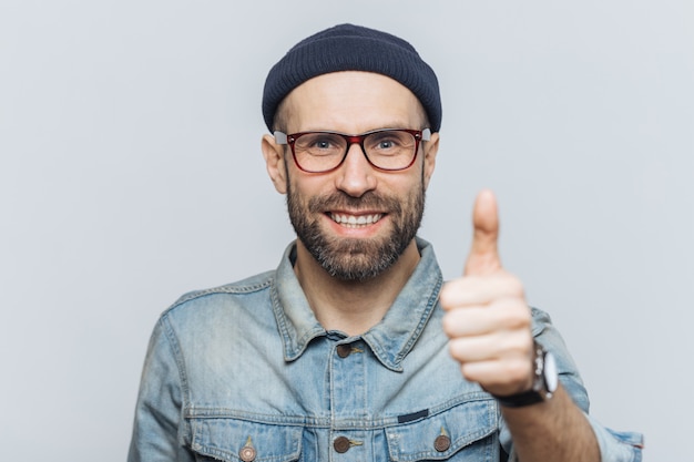 Varón de mediana edad positivo con espesa barba y bigote, muestra un signo aceptable, levanta el pulgar