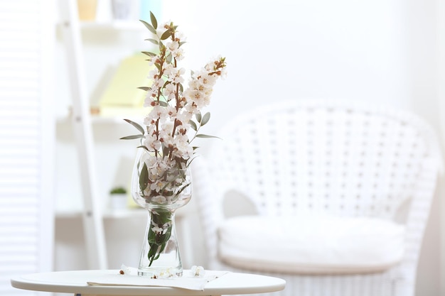 Vase mit blühenden Frühlingszweigen auf dem Tisch