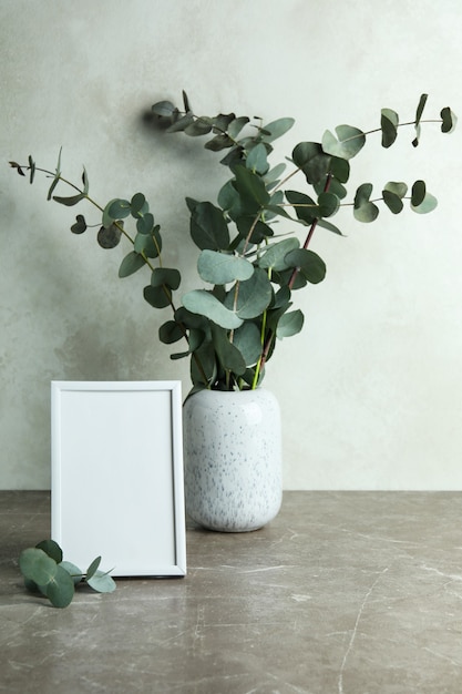 Vase mit Eukalyptuszweigen und Fotorahmen
