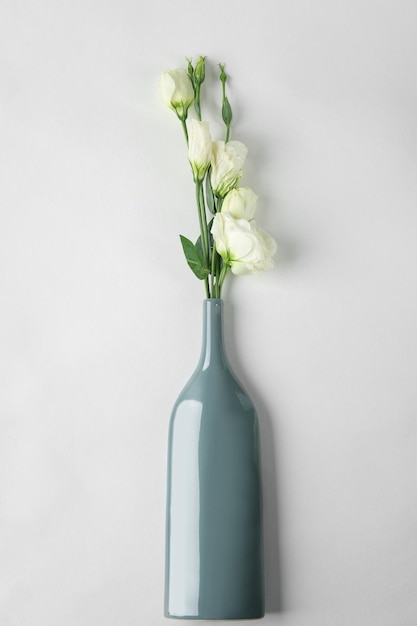 Vase mit schönen Blumen auf weißem Hintergrund