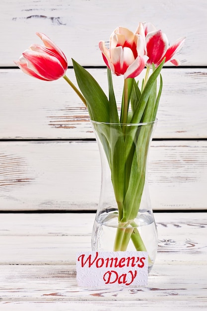 Vase mit Tulpen und Karte Herzlichen Glückwunsch zum Frauentag