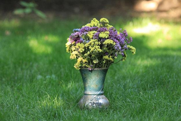 Vase mit Wildblumen auf dem Rasen