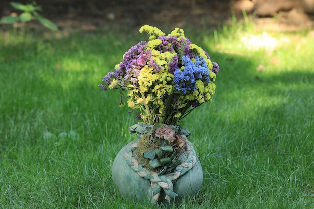 Vase mit Wildblumen auf dem Rasen