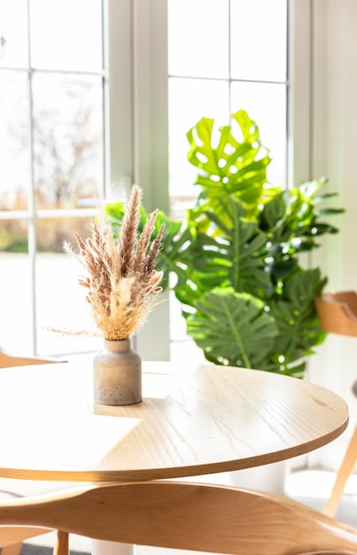 Vasen mit Blumenstrauß aus Trockenblumen auf Holztisch Minimalistisch in der Innenarchitektur des Cafés