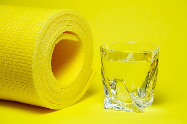 Vaso de agua, alfombra amarilla, fondo de color, deportes, ingeniero de energía, equipo de gimnasia