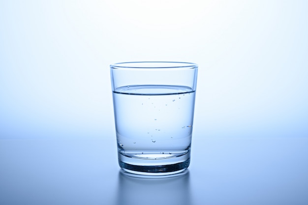 Foto vaso de agua clara sobre fondo azul.