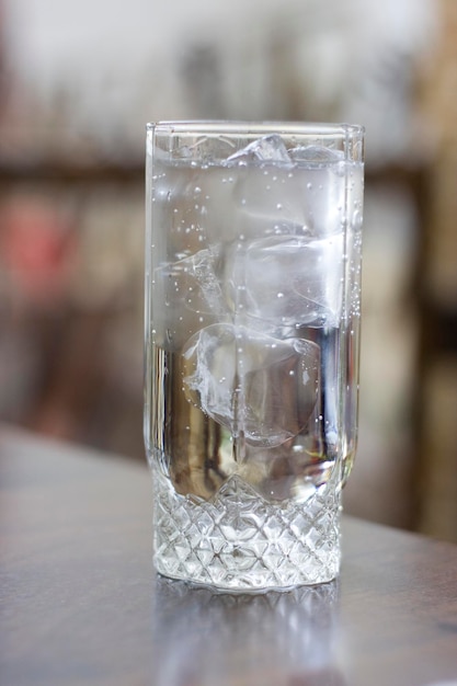 Vaso con agua dulce y hielo sobre la mesa.