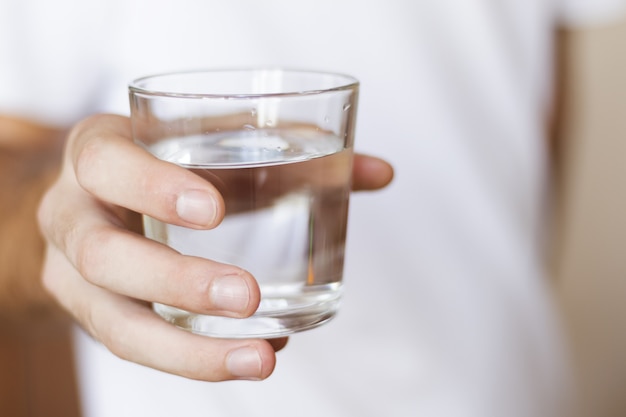 vaso de agua dulce en la mano