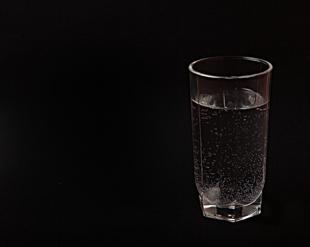 Un vaso de agua fondo negro