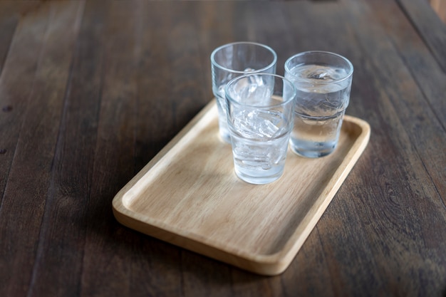 Vaso de agua fría colocado en una mesa de madera