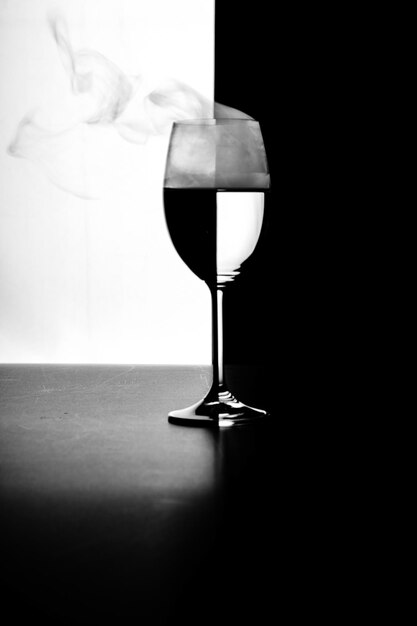 Un vaso de agua y humo sobre un fondo blanco y negro.