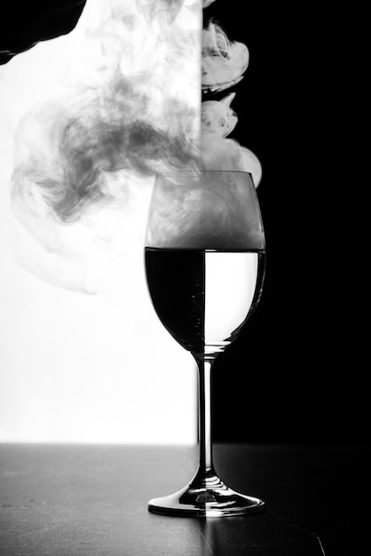 Un vaso de agua y humo sobre un fondo blanco y negro.