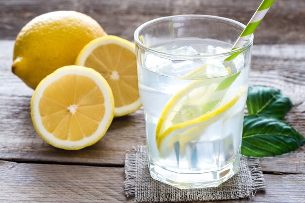 Vaso de agua con jugo de limón fresco y hielo.