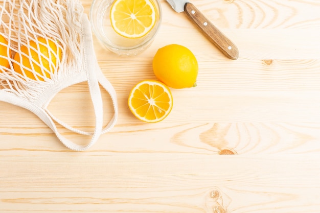 Vaso de agua con limón sobre una mesa de madera, bebida matutina para un estilo de vida saludable