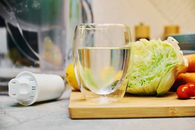 Vaso de agua limpia y verduras