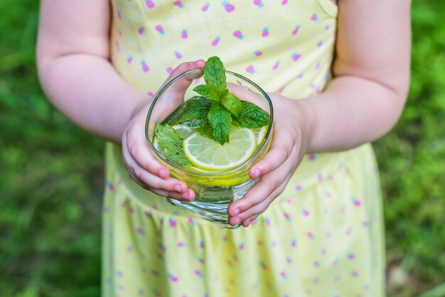 Vaso de agua en manos de los niños.