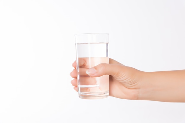 Un vaso de agua mineral limpia en manos de la mujer. Bebida saludable concepto