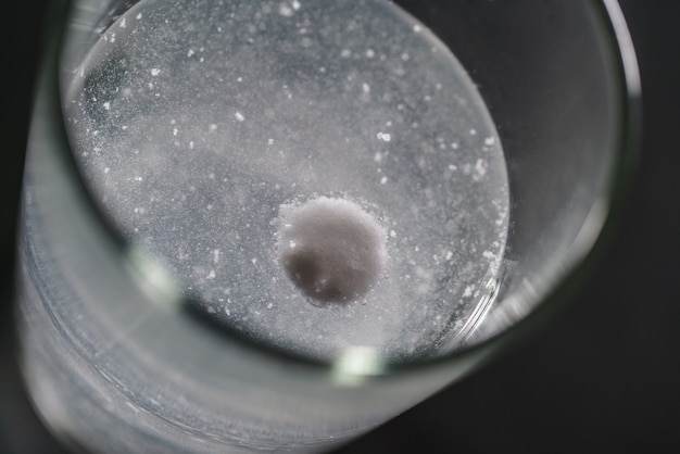 Vaso de agua y pastillas aisladas en blanco