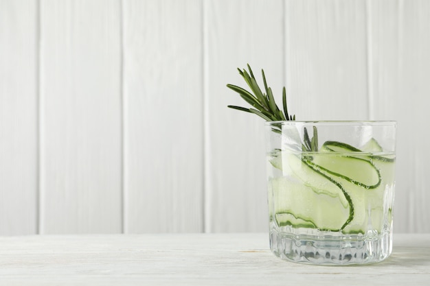 Vaso de agua de pepino en mesa de madera