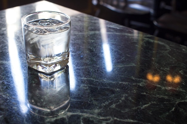 Vaso de agua con un poco de hielo sobre la mesa