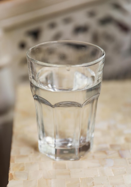 Un vaso de agua se sienta en una encimera.