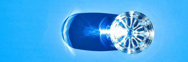 Foto vaso de agua sobre fondo azul con luz dura y sombras, reflejos sobre el agua. bebidas alcohólicas. sediento. vodka