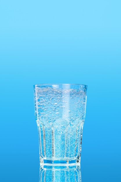 Foto vaso de agua sobre un fondo azul