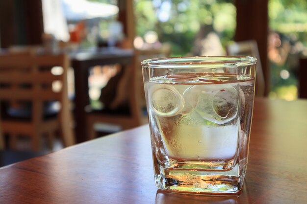 Vaso de agua sobre la mesa de madera en el restaurante